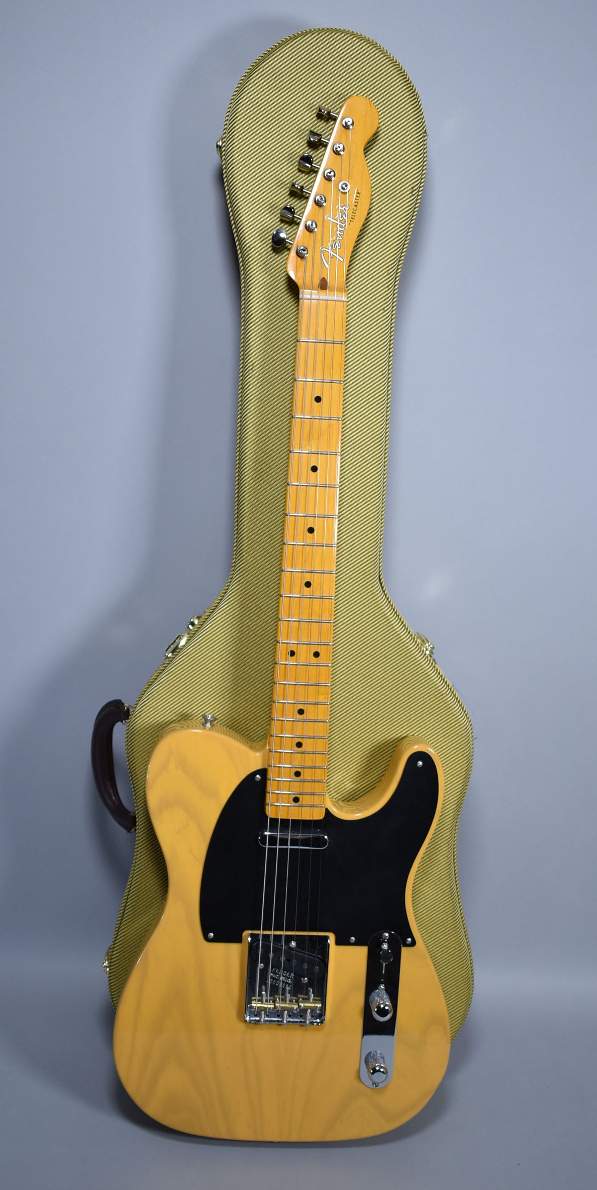 Full-length, light blonde Telecaster with a black pickguard and maple neck, resting in a tweed hard shell case.