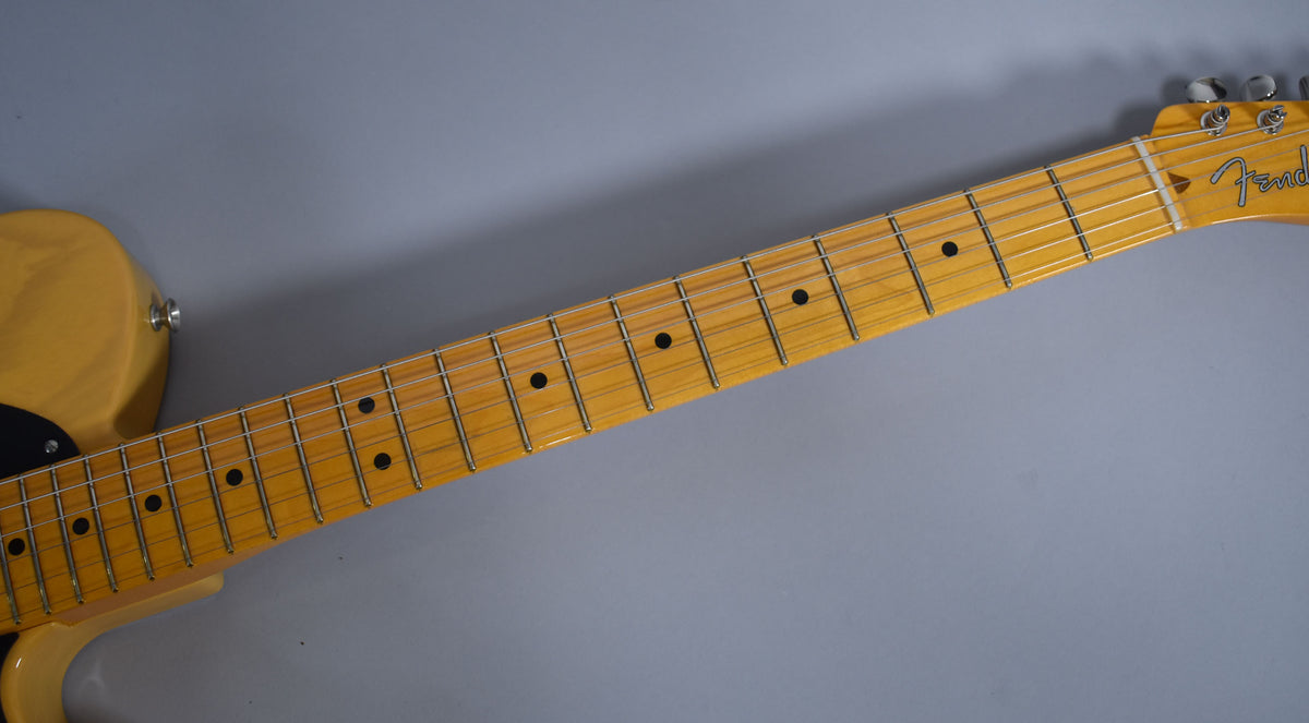 The butterscotch blonde Telecaster's maple neck and fretboard with black dot inlays are shown from the body to the headstock.
