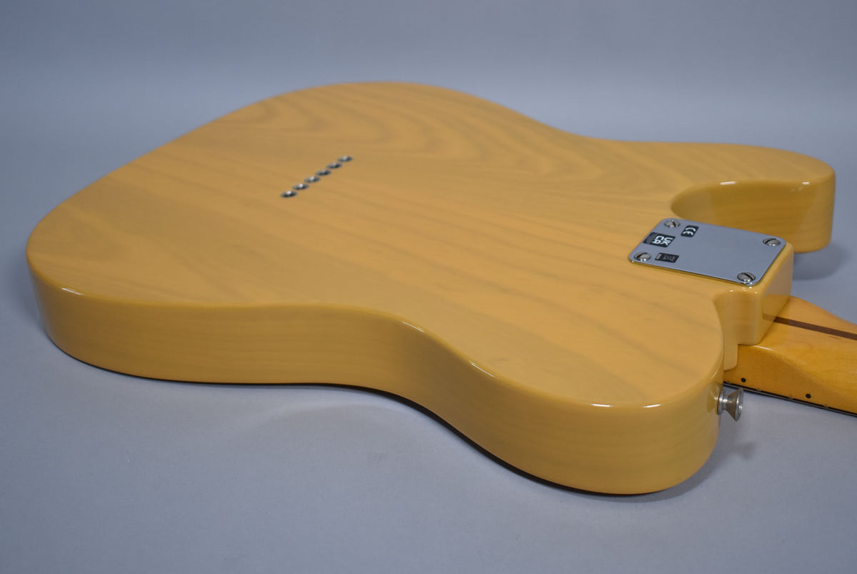 The back of a blonde Telecaster body, showing the string-through ferrules, neck plate, and output jack.