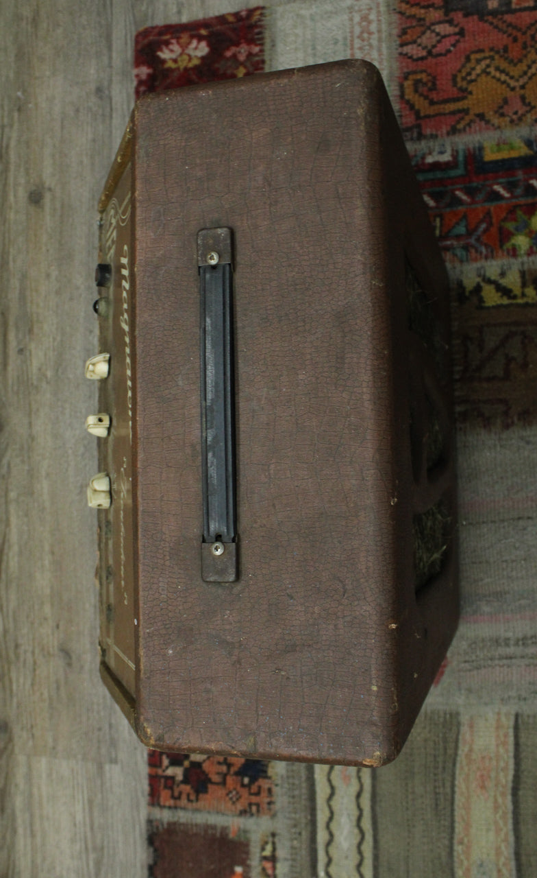 Top-down view of the brown, cracked-finish amp, showing its black handle and three cream control knobs on the left side.