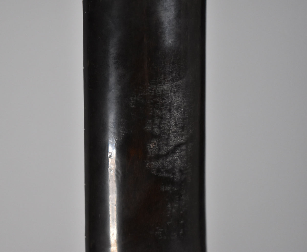 Close-up of the dark brown neck, showing significant finish wear and checking, with lighter reflections on the left edge.