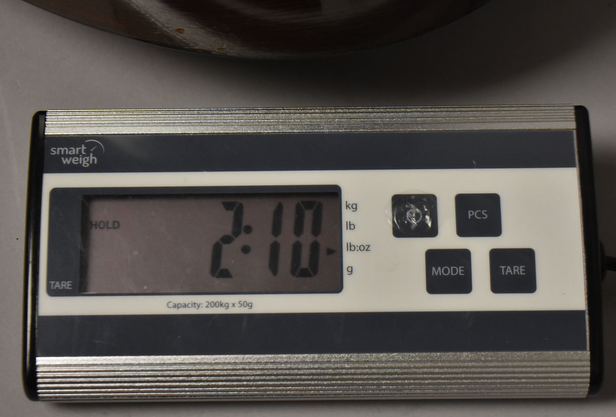 A digital scale shows "2.10" in pounds, with the guitar's dark brown body partially visible at the top.