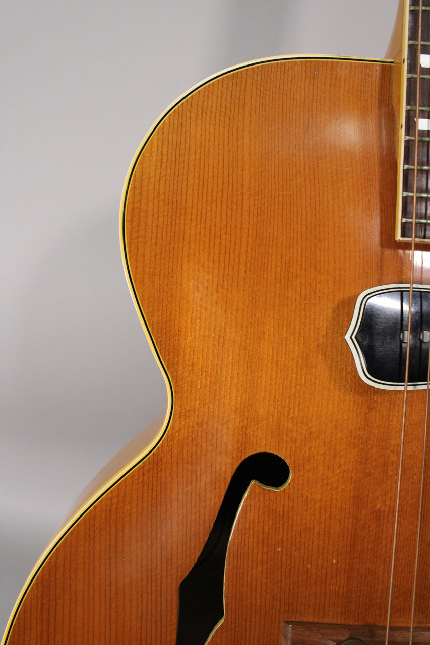 Close-up of the guitar's natural finish body, showing the upper bout, f-hole, and a black DeArmond pickup near the fretboard.