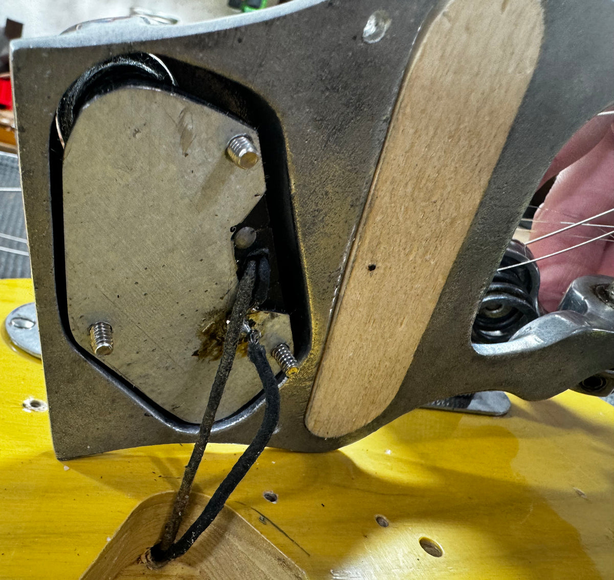 Close-up of the guitar's bridge pickup cavity, showing the metal pickup cover, wiring, and the butterscotch blonde body with exposed wood.