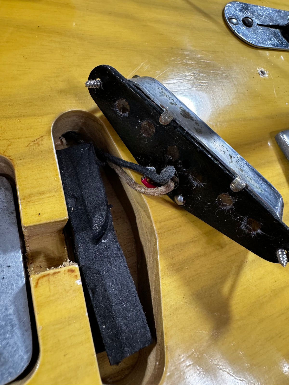 Close-up of the butterscotch blonde body, showing the bridge pickup removed, revealing wiring and the pickup cavity.