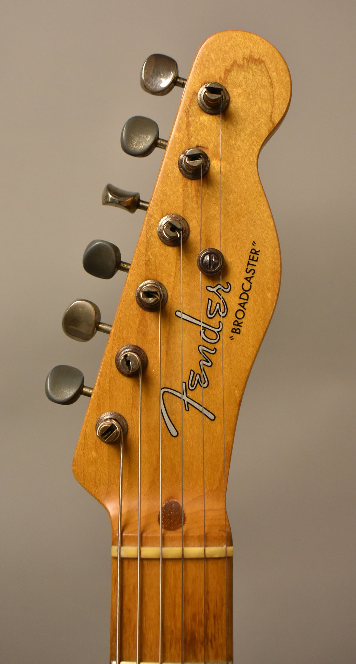 Close-up of the guitar's butterscotch blonde headstock and upper neck, showing six tarnished tuners and visible wear on the wood.