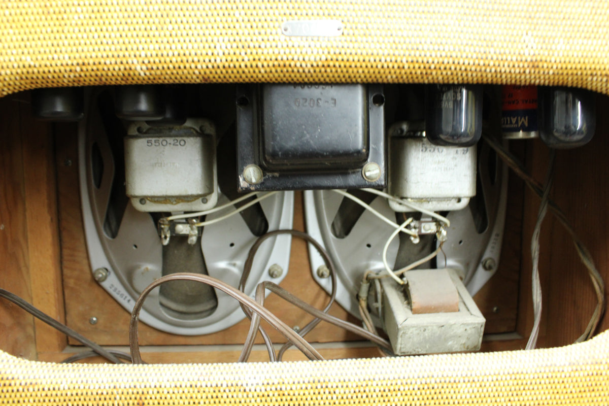 Rear view of the amp's interior, showing two silver speakers, a black transformer, and several vacuum tubes and wires.