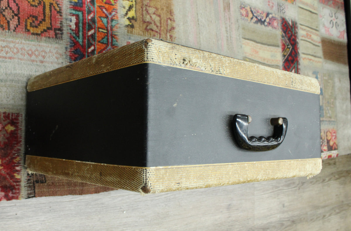 Top-down view of the black amp with tweed trim, showing the black plastic handle and some wear on the tweed edges.