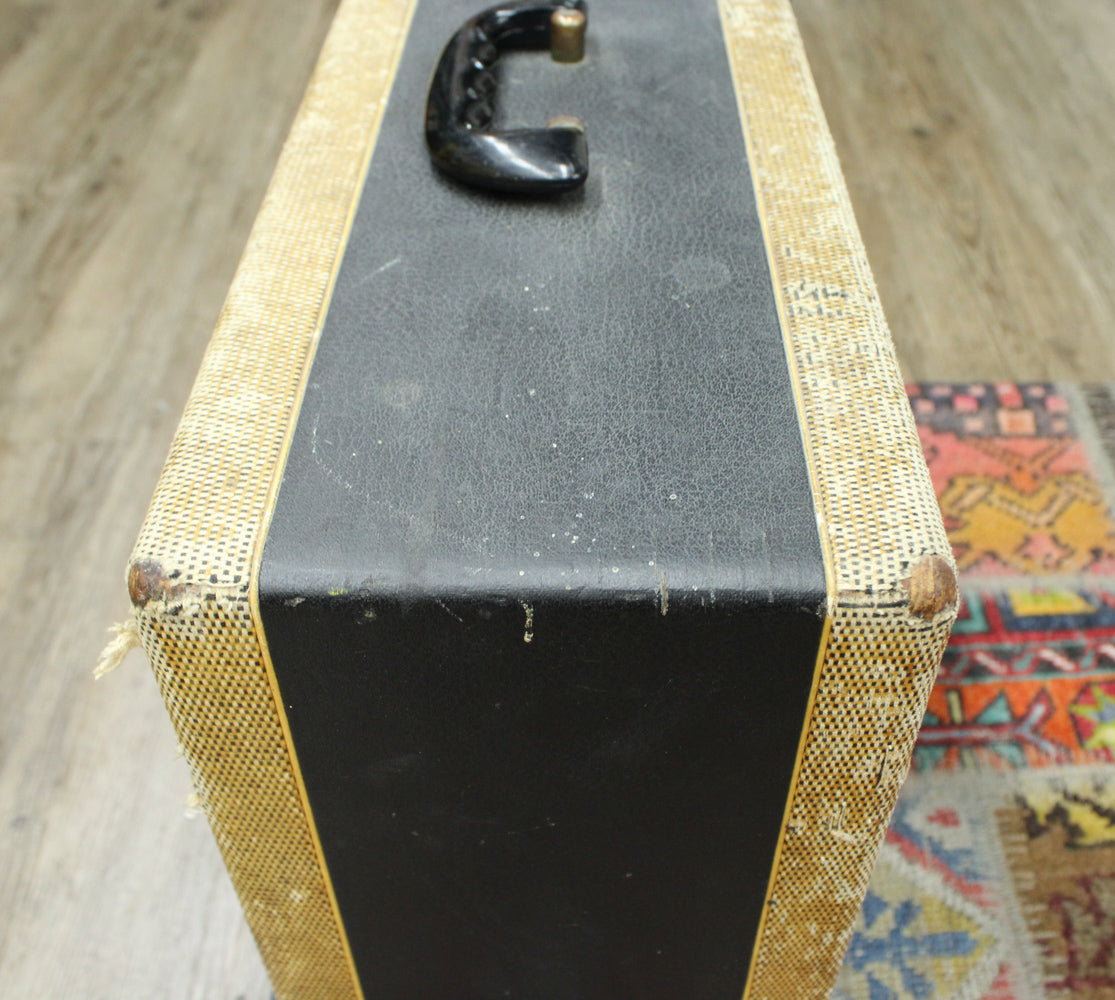 Top-down view of the amp's black textured top and tweed sides, showing a black handle and worn corners with exposed wood.