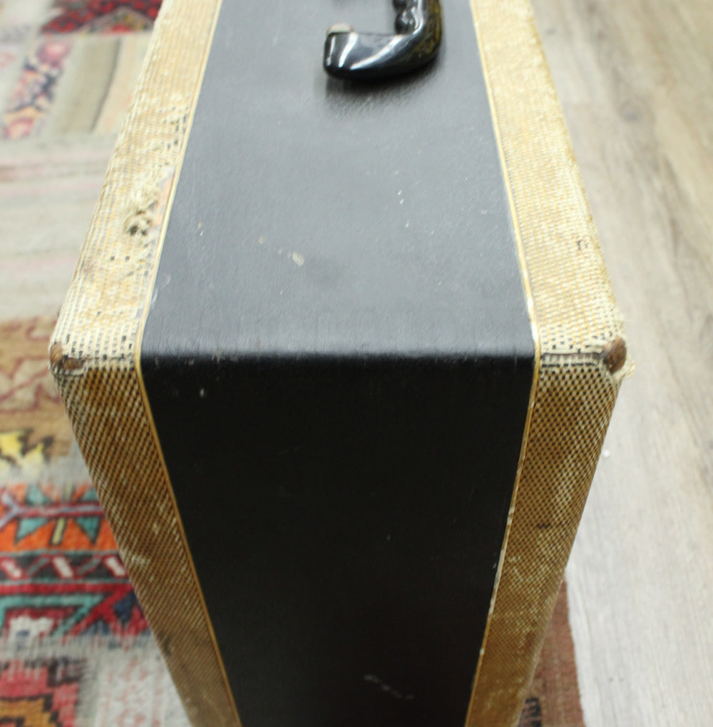 Top-down view of the amp, showing the black top panel with a worn handle, and tweed sides with frayed corners.