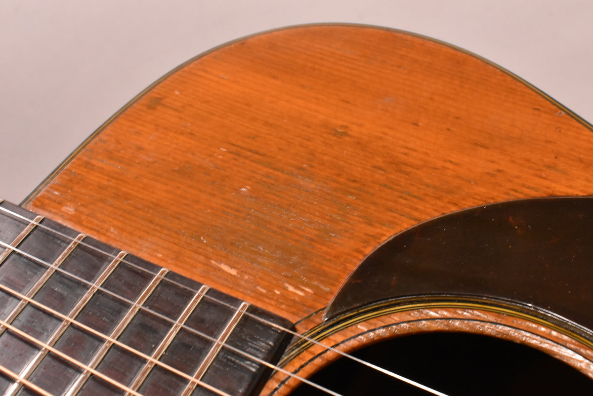 Close-up of the guitar's natural finish top, showing significant play wear and finish loss near the pickguard and fretboard.