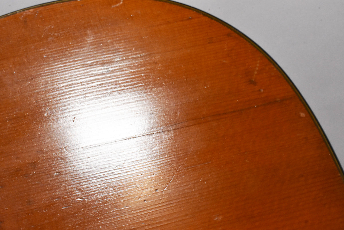 Close-up of the guitar's lower bout, showing the natural wood grain, a glossy finish with visible checking, scratches, and dings.