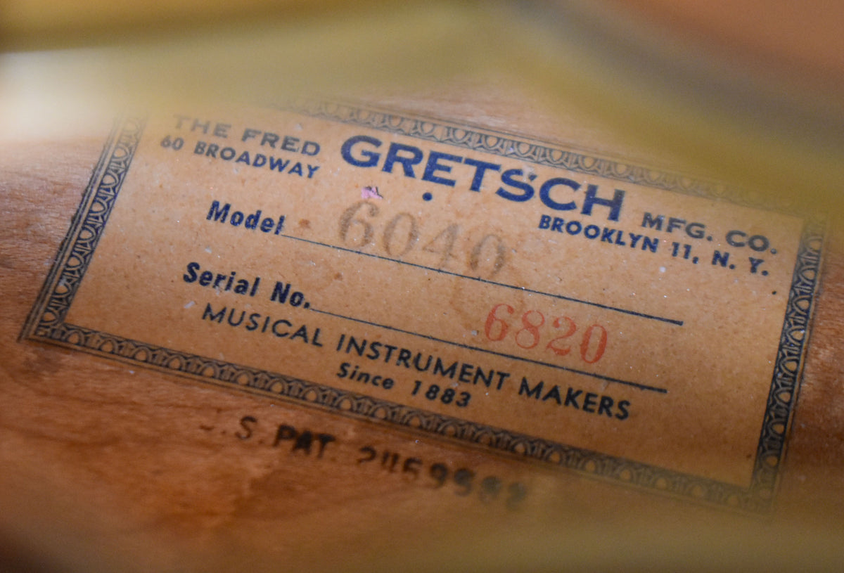 Close-up of the guitar's interior label, showing "Model 6040" and "Serial No. 6820" on aged paper with a decorative border.