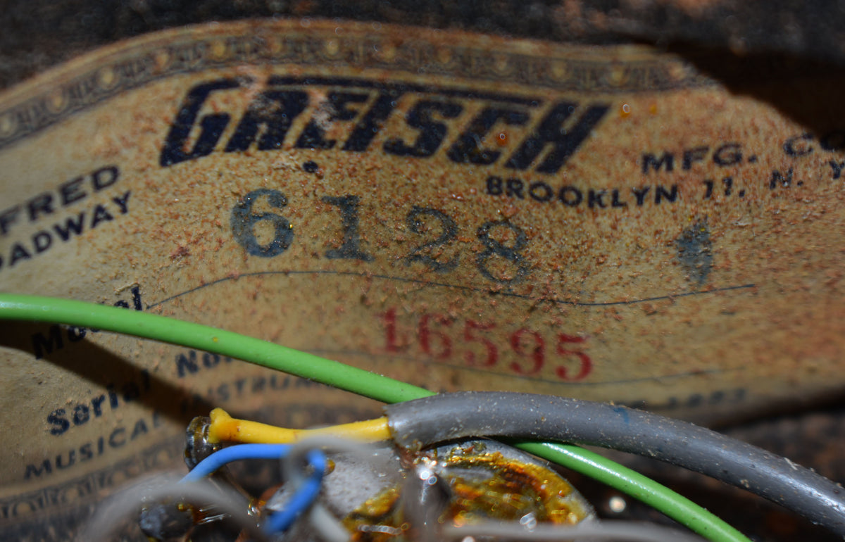 Close-up of the guitar's internal label, showing "6128" in black and "16595" in red, with various colored wires and solder joints.