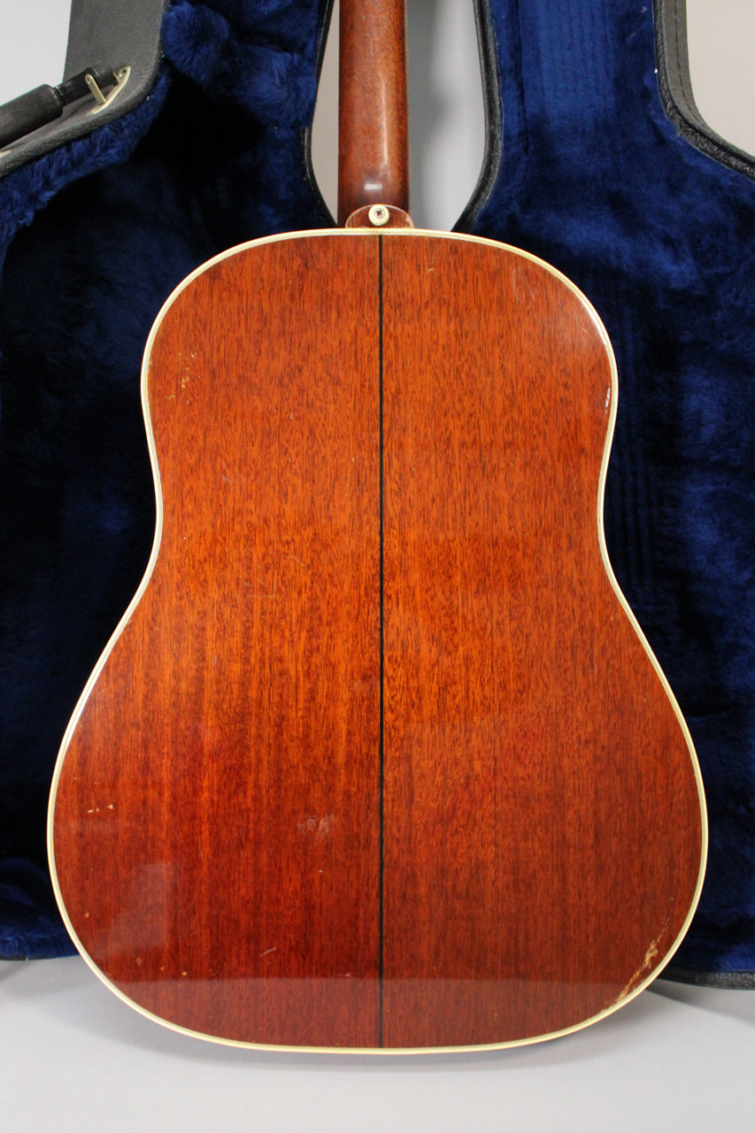 The guitar's back, a rich reddish-brown with visible wood grain, shows light scratches and finish checking, with a white binding.