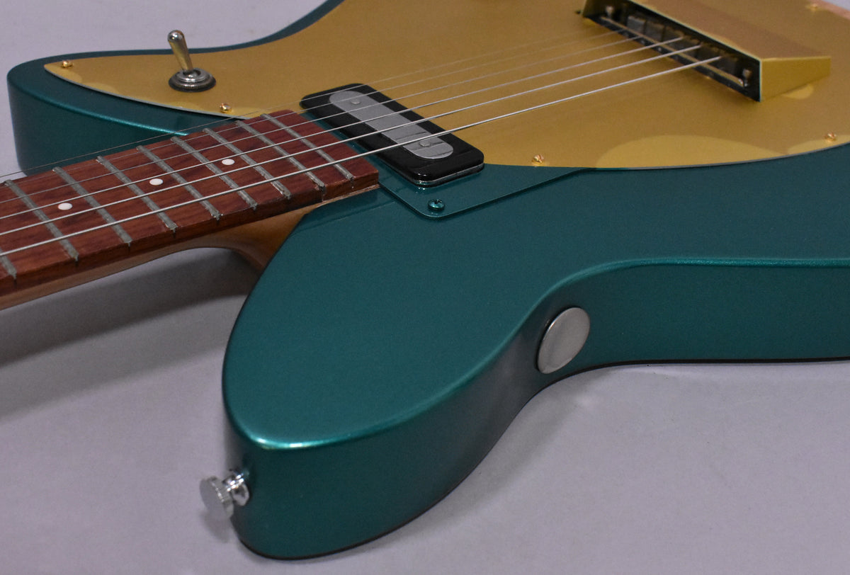 Close-up of the Cloverfield Green body and gold pickguard, showing the neck pickup, toggle switch, and input jack.