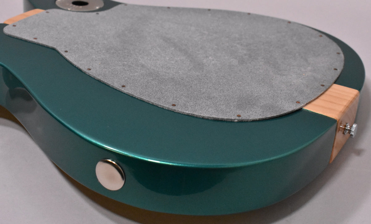 Close-up of the guitar's Cloverfield Green back, showing the grey felt pad, output jack, and a chrome strap button.