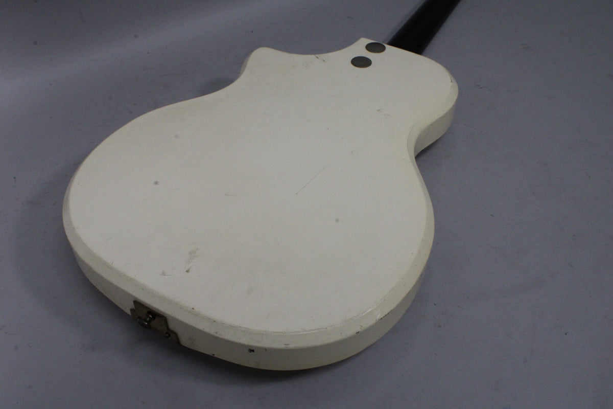 The back of the white guitar body, showing light scratches, two strap buttons, and a small metal plate near the bottom edge.