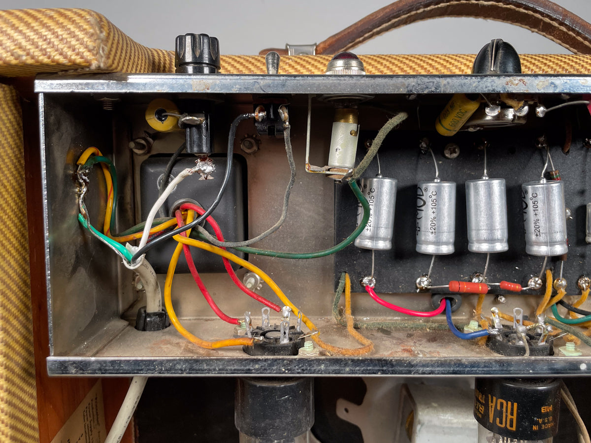 Close-up of the amp's internal chassis, revealing wiring, capacitors, resistors, and a tube socket, with some dust visible.