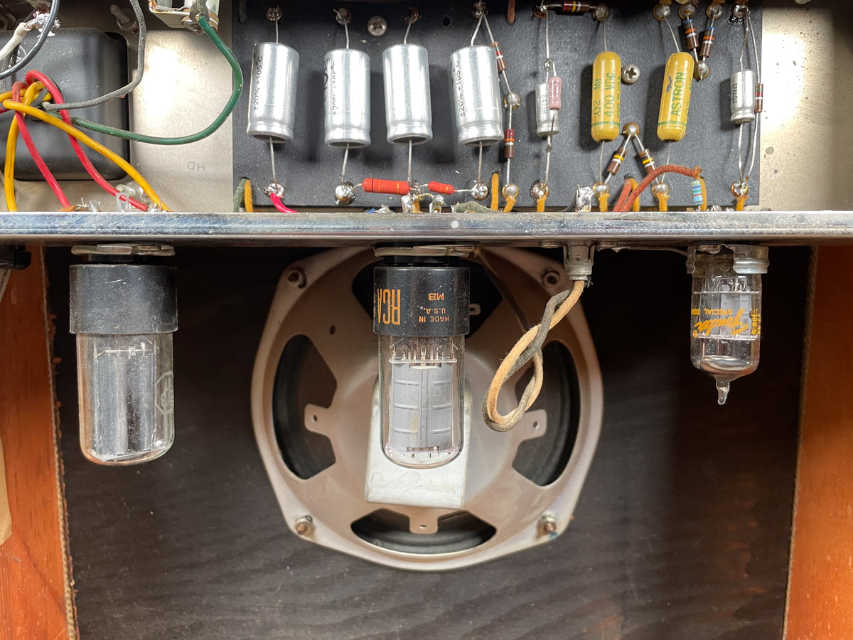 Top-down view of the amp's interior, showing the speaker, three vacuum tubes, and various capacitors and wiring.