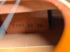 Inside the guitar's soundhole, a light brown wooden brace with "S760 22" stamped in black is visible, along with other internal bracing.