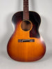 Full-frame view of the sunburst acoustic guitar, showing a dark tortoise pickguard and visible finish checking on the body.