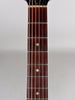 A close-up of the dark brown fretboard with six strings, showing three circular fret markers and light wear on the frets.