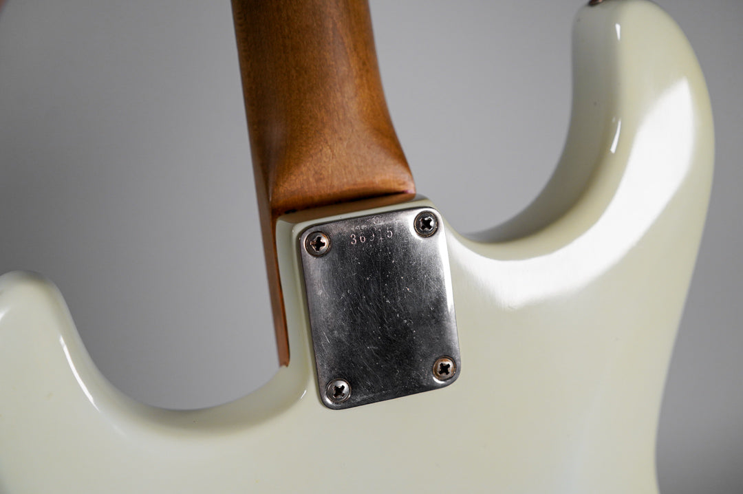 Close-up of the guitar's white body and neck joint, showing the worn, four-screw neck plate with the serial number "36315".