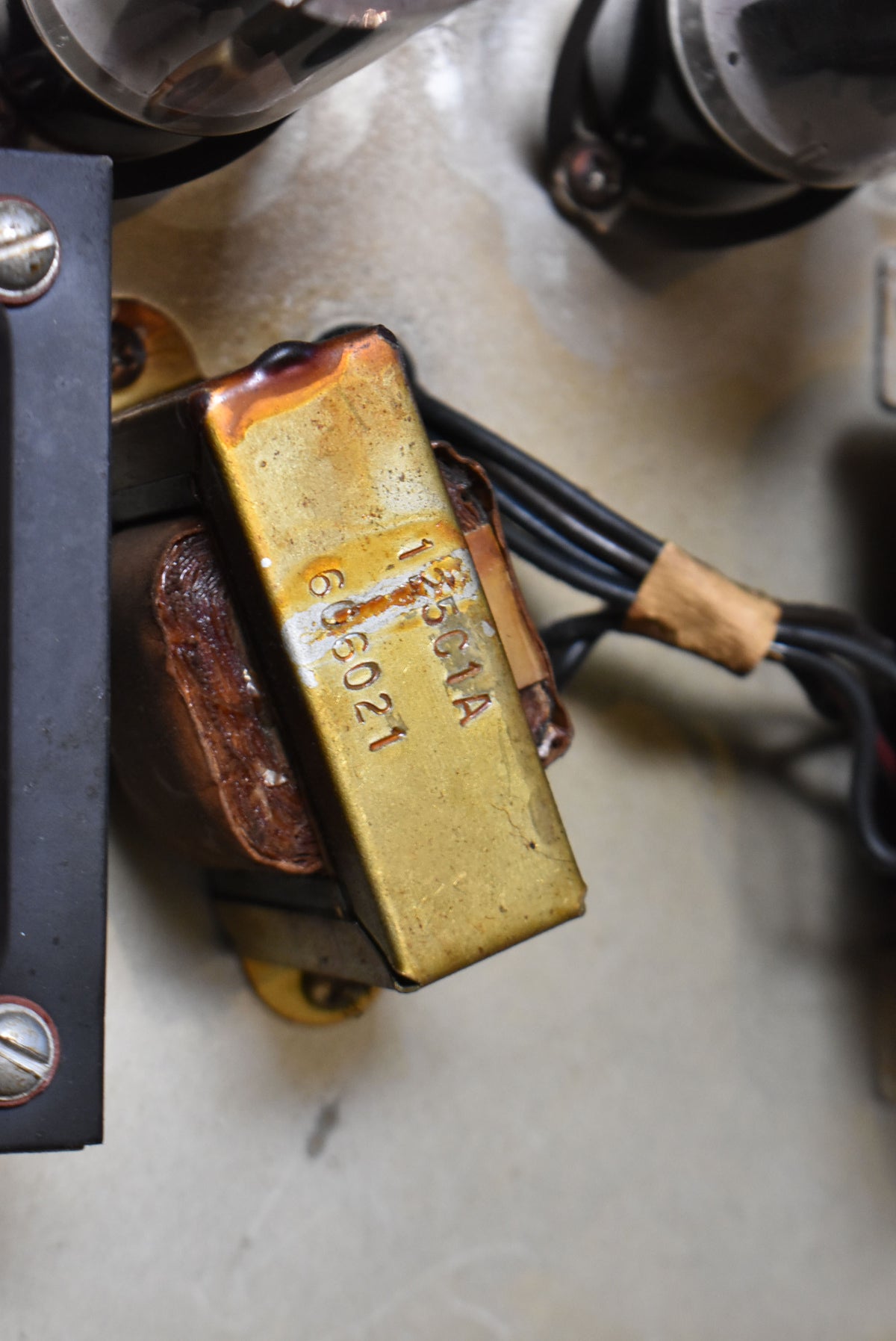 A close-up of the amp's internal components, showing a tarnished brass transformer with stamped numbers and wrapped wires.