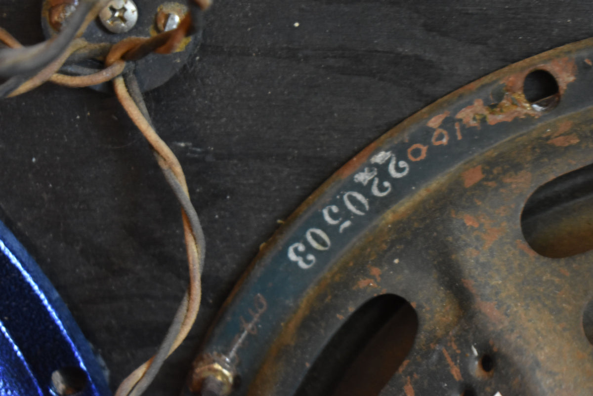 Close-up of a rusty speaker frame with white numbers "220503" and exposed wiring, showing heavy wear and corrosion.