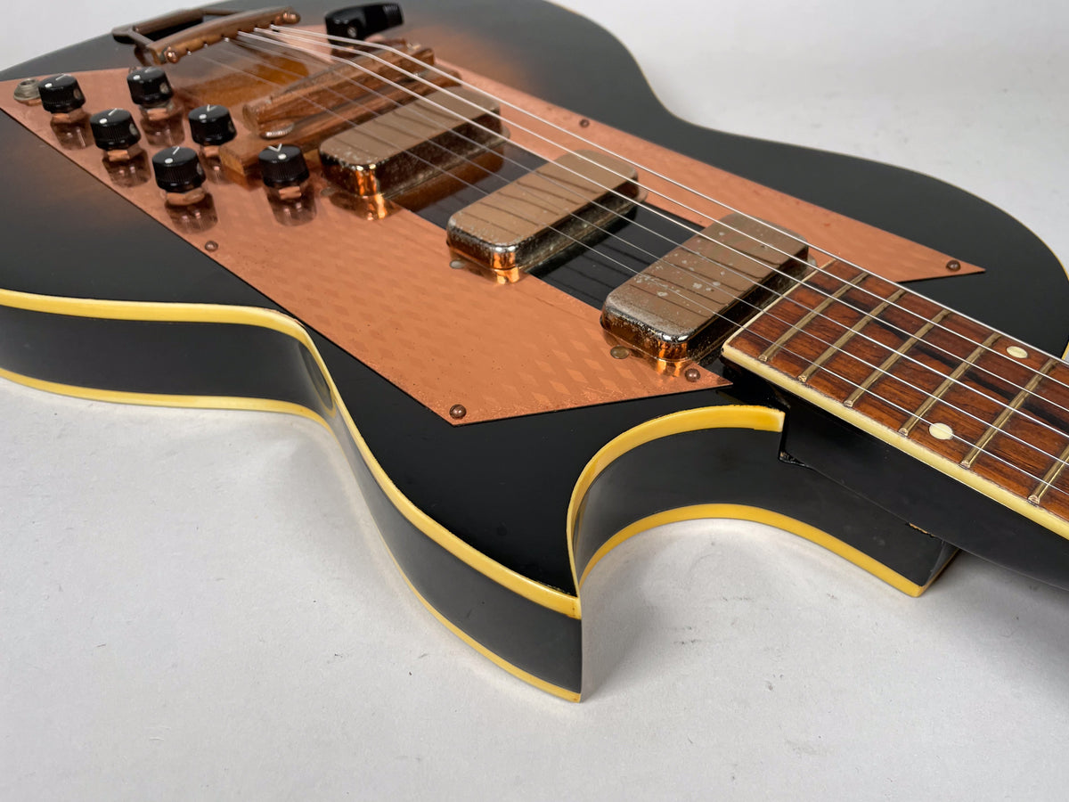 Close-up of the sunburst body, showing the copper pickguard, six black knobs, three pickups, and the lower fretboard.