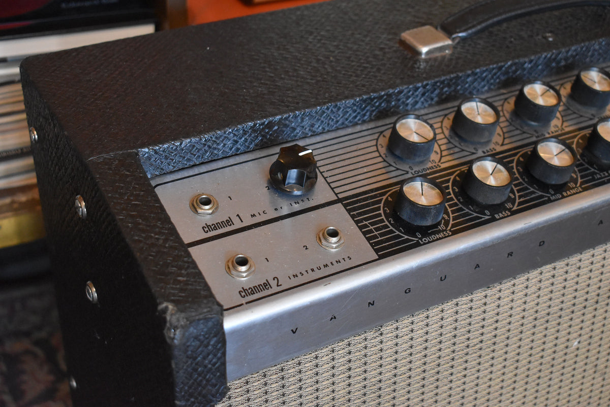 Close-up of the amp's black textured top and front control panel, showing input jacks, a single black knob, and several silver-capped black knobs.