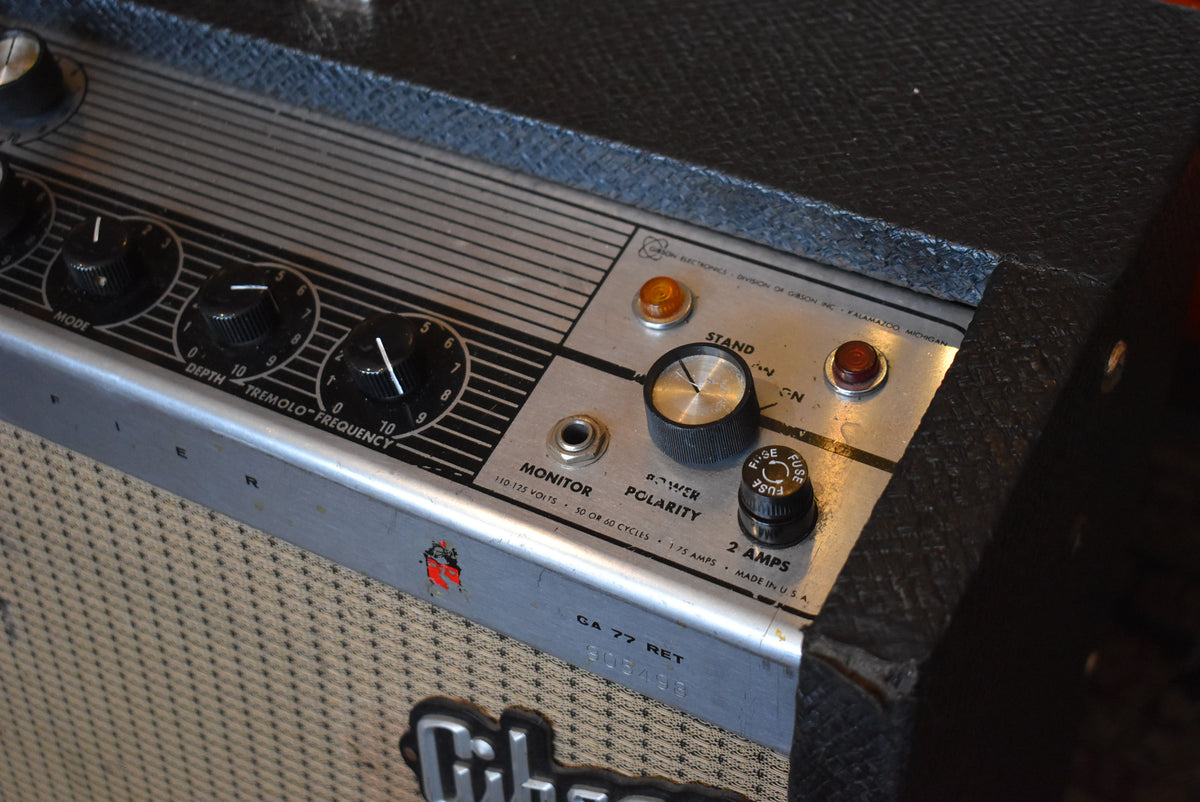 Close-up of the amp's silver control panel with black knobs, amber and red pilot lights, and a black textured Tolex top.