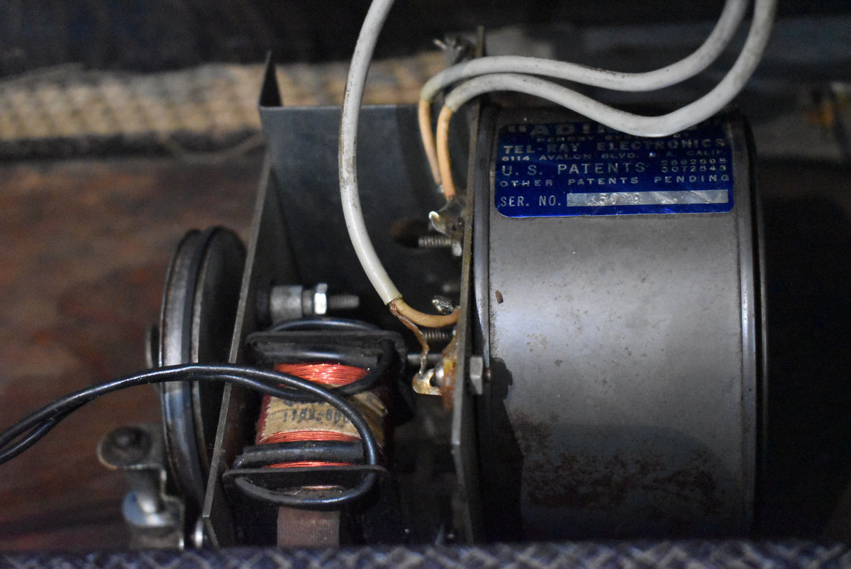 A close-up of the amplifier's internal components, showing a large grey cylindrical part with a blue label and copper-wound coils.