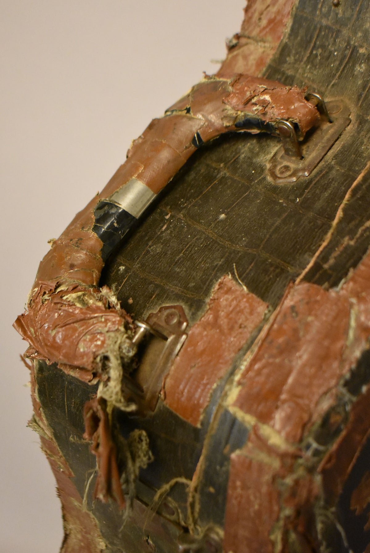 Close-up of the case handle, showing heavily worn, peeling reddish-brown faux alligator skin and exposed dark wood underneath.