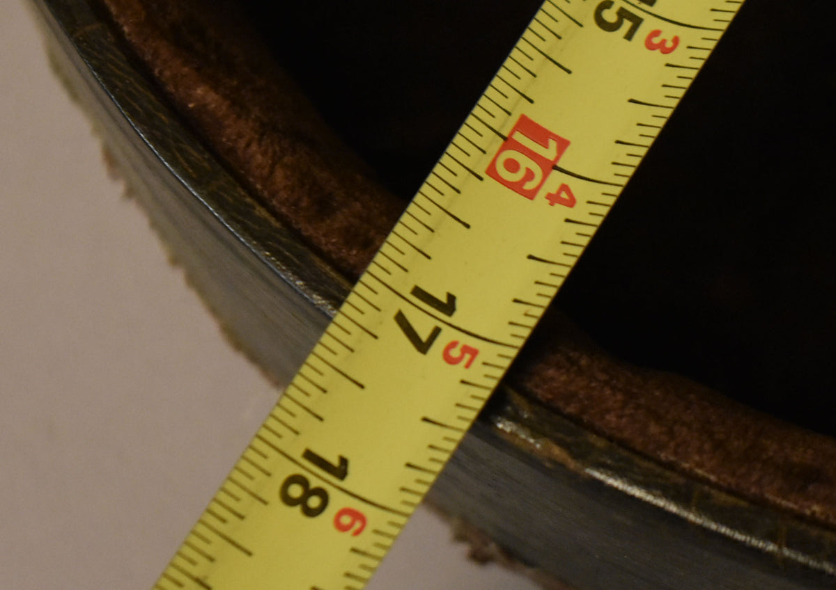 A yellow tape measure shows the case's faux alligator exterior and brown plush interior, with some wear visible on the edges.