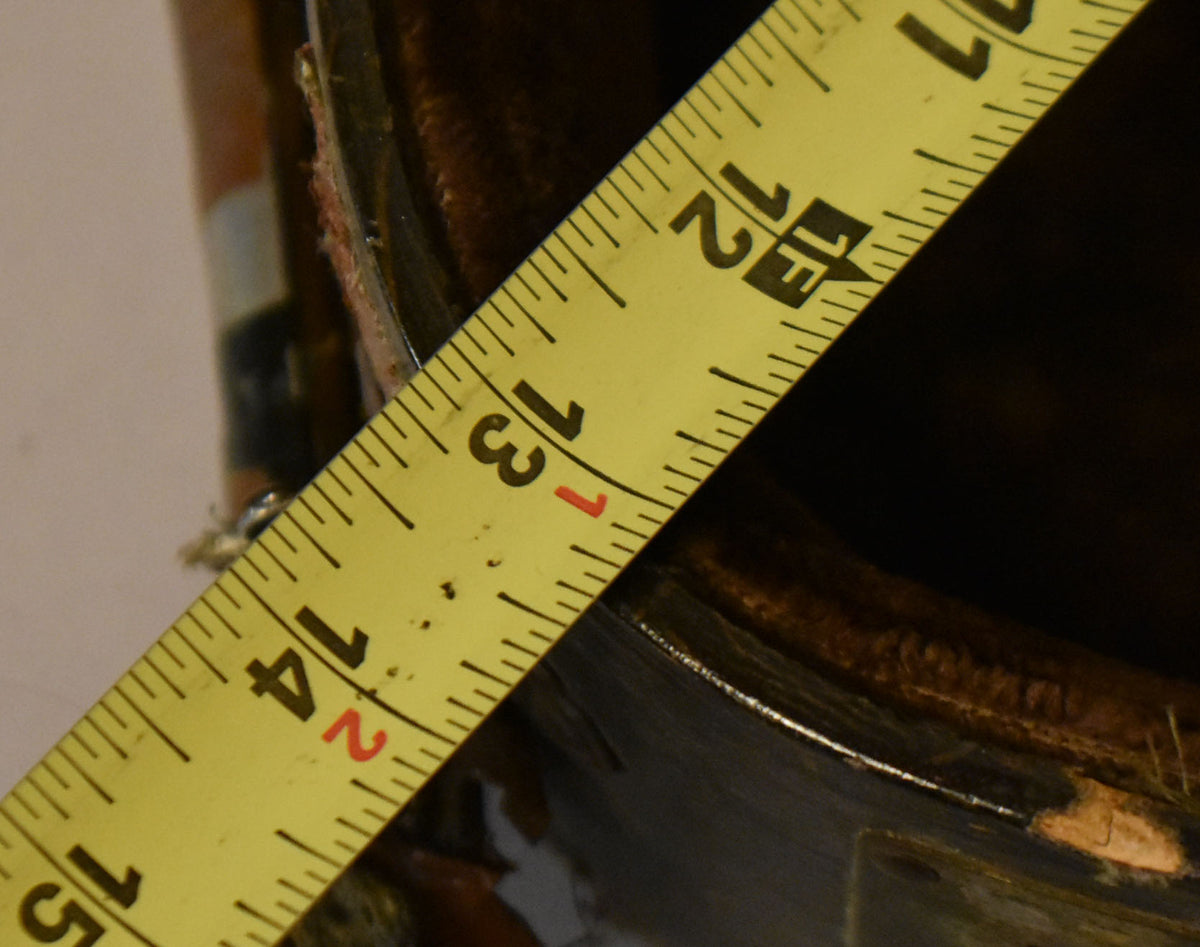 A yellow tape measure shows 11 to 15 inches across the dark brown faux alligator case, revealing wear and exposed wood.