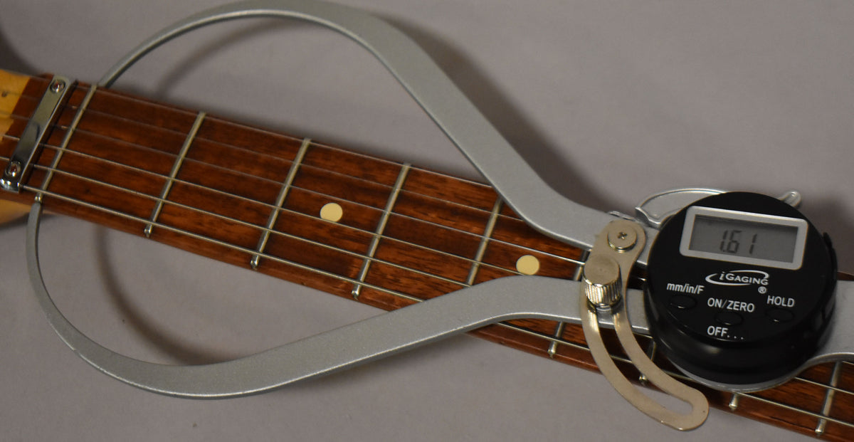 A digital fret height gauge measures 1.61mm on the dark rosewood fretboard with dot inlays and light wear.