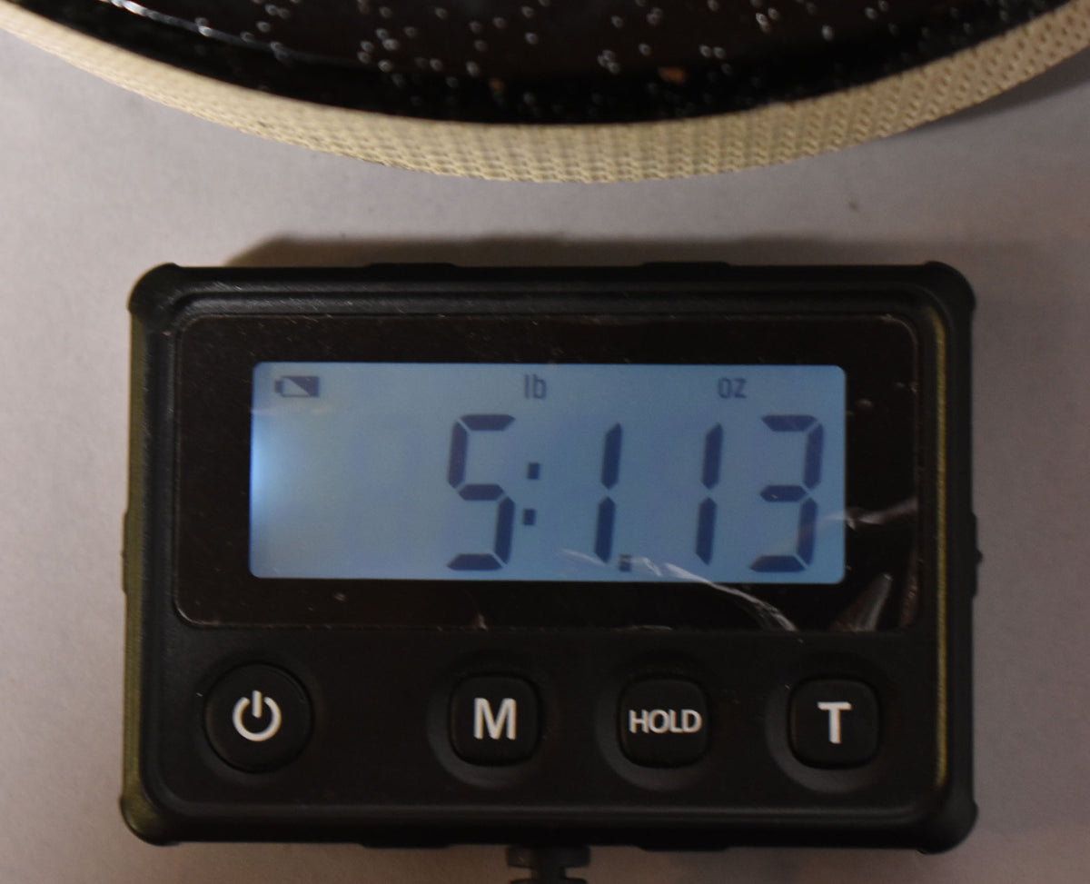A digital scale displays "5:113" in lb and oz, with a dark speckled object partially visible above it.