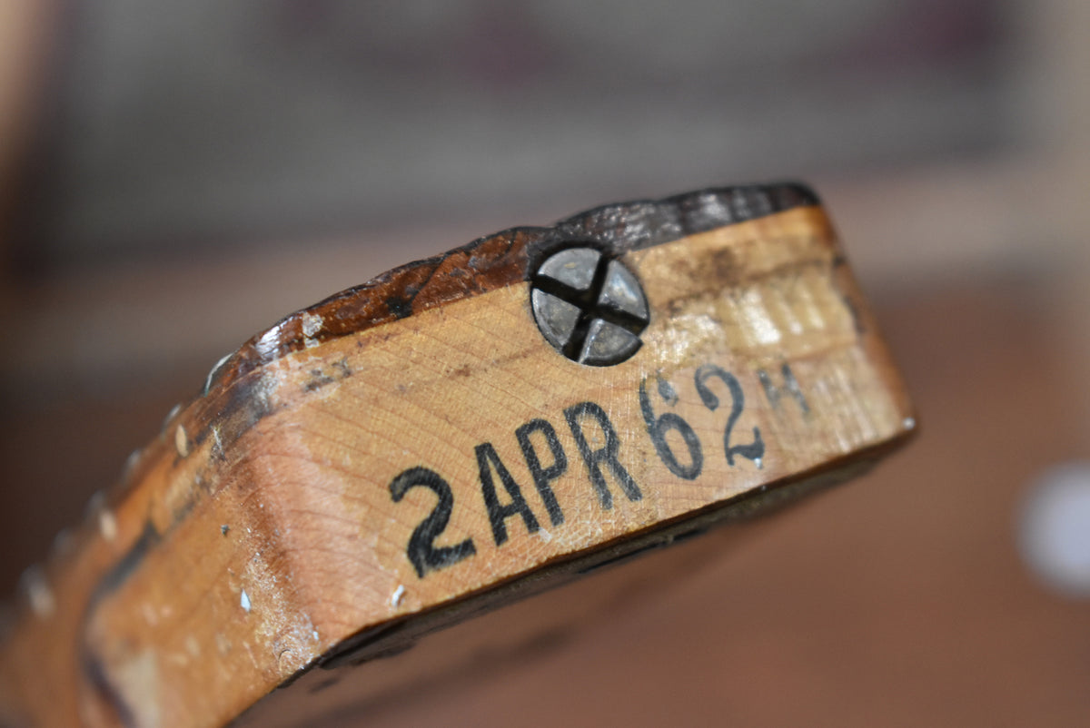 Close-up of the guitar neck heel, showing a metal screw and "2 APR 62" stamped in black ink on the light wood.