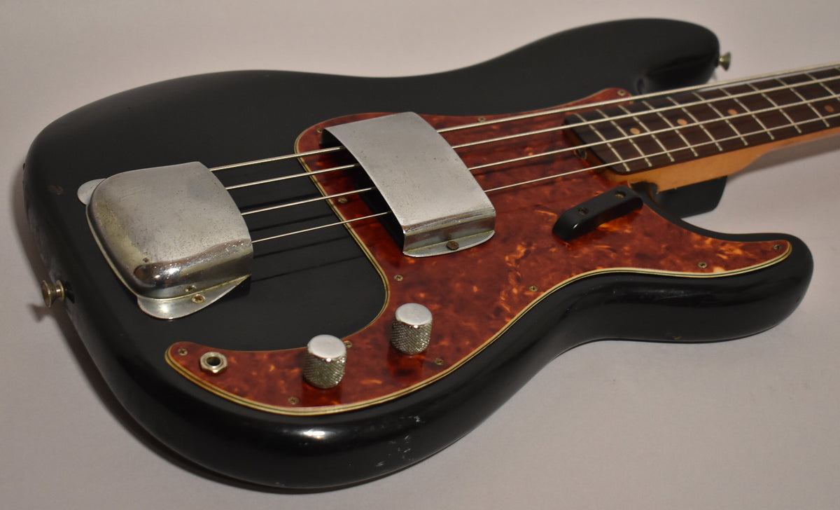 Black refinished bass body with a tortoiseshell pickguard, chrome bridge and pickup covers, and two knurled chrome knobs.