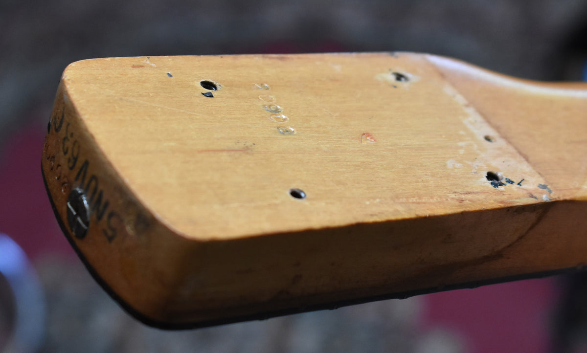 Close-up of the neck heel, showing the light wood finish, four screw holes, and "5NOV63C" stamped on the curved end.