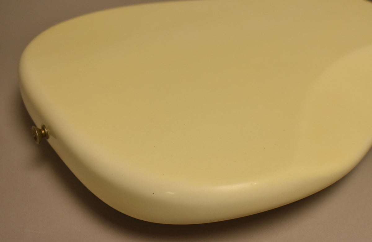 The Olympic White bass body, viewed from above, shows a strap button on the lower bout and a few small dark blemishes on the finish.