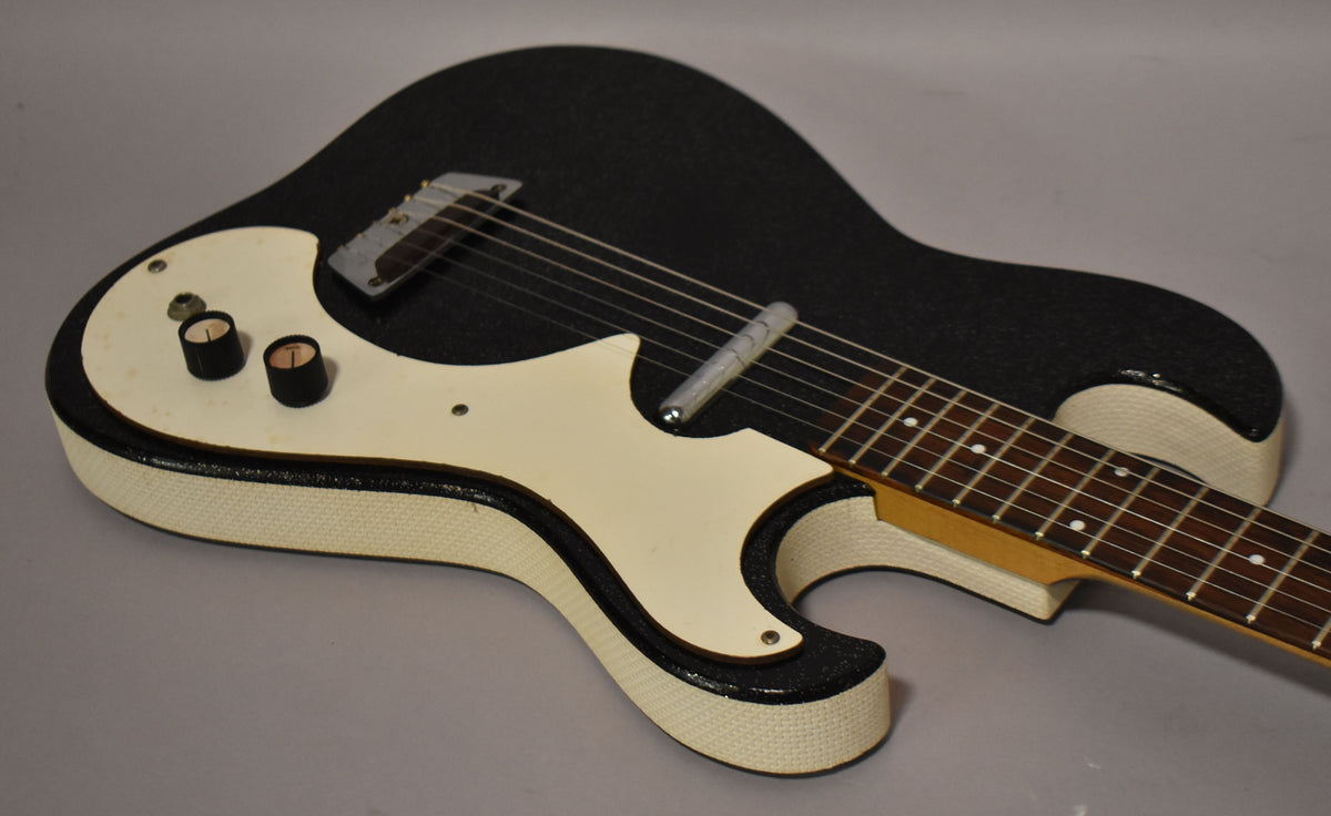 Upper body of a black sparkle guitar with a white pickguard, two black knobs, and a single pickup.