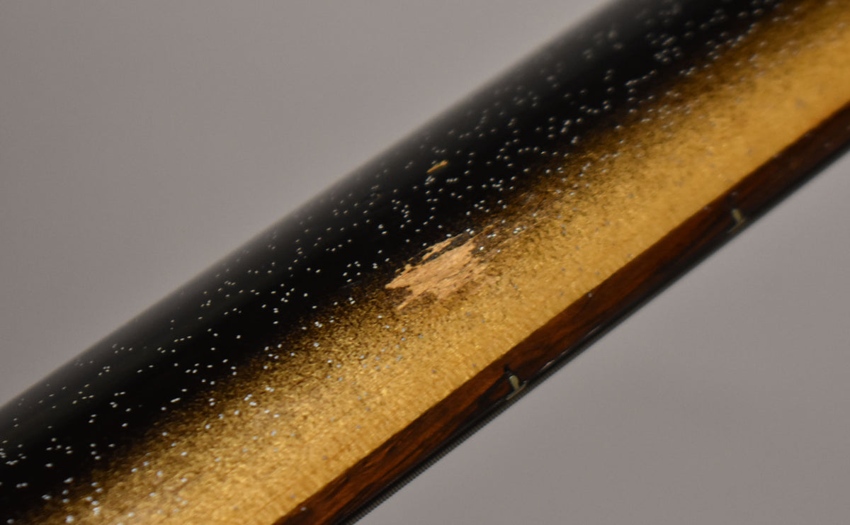 Close-up of the guitar's black and gold sparkle finish, showing significant wear and chipping on the gold section of the body.