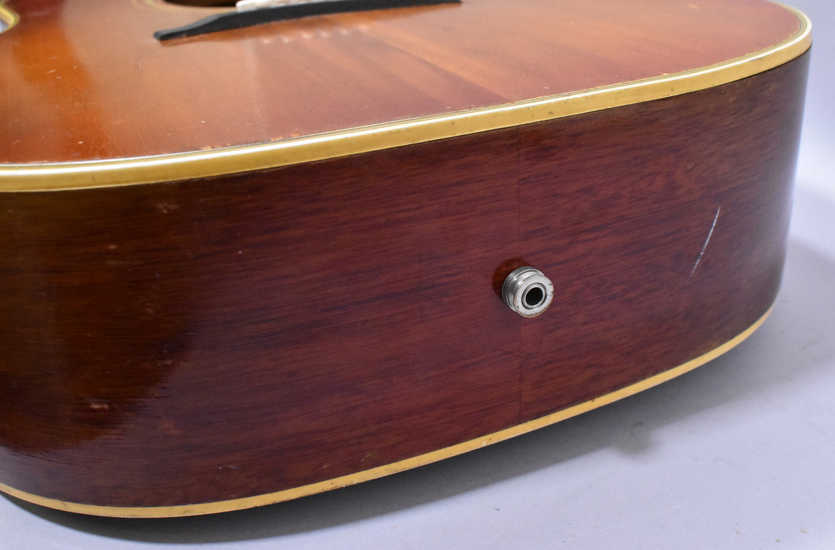 Close-up of the guitar's lower bout, showing the dark reddish-brown side with a chrome output jack and light scratches.