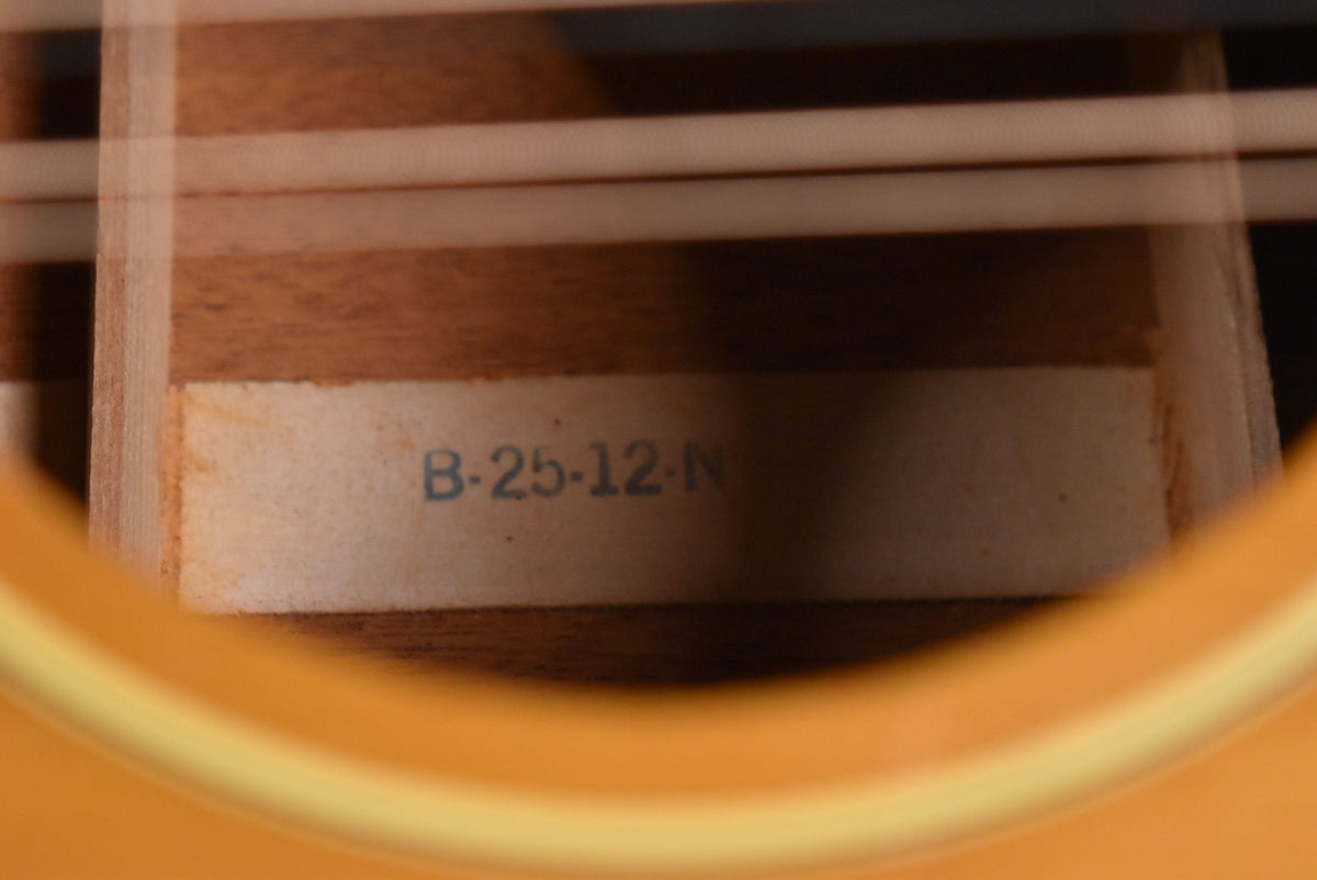 A close-up of the guitar's interior, showing a faded white label with "B-25-12-N" printed in blue, visible through the soundhole.