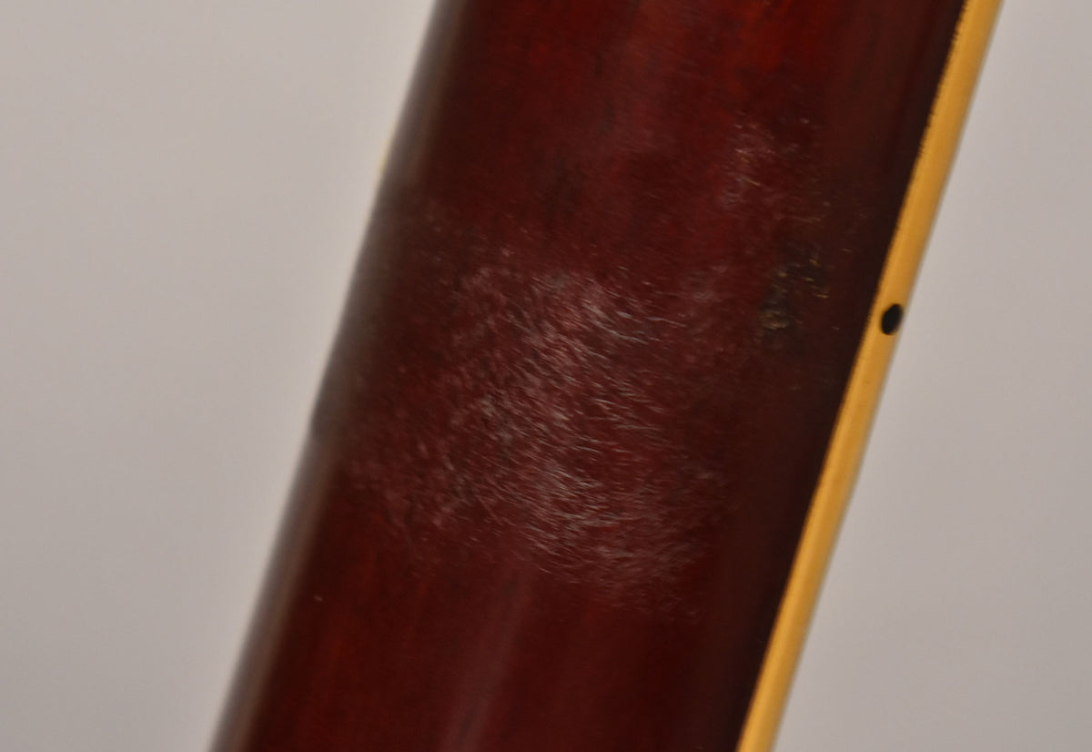 Close-up of the cherry red guitar neck, showing extensive finish checking and wear, with a single black side dot marker.