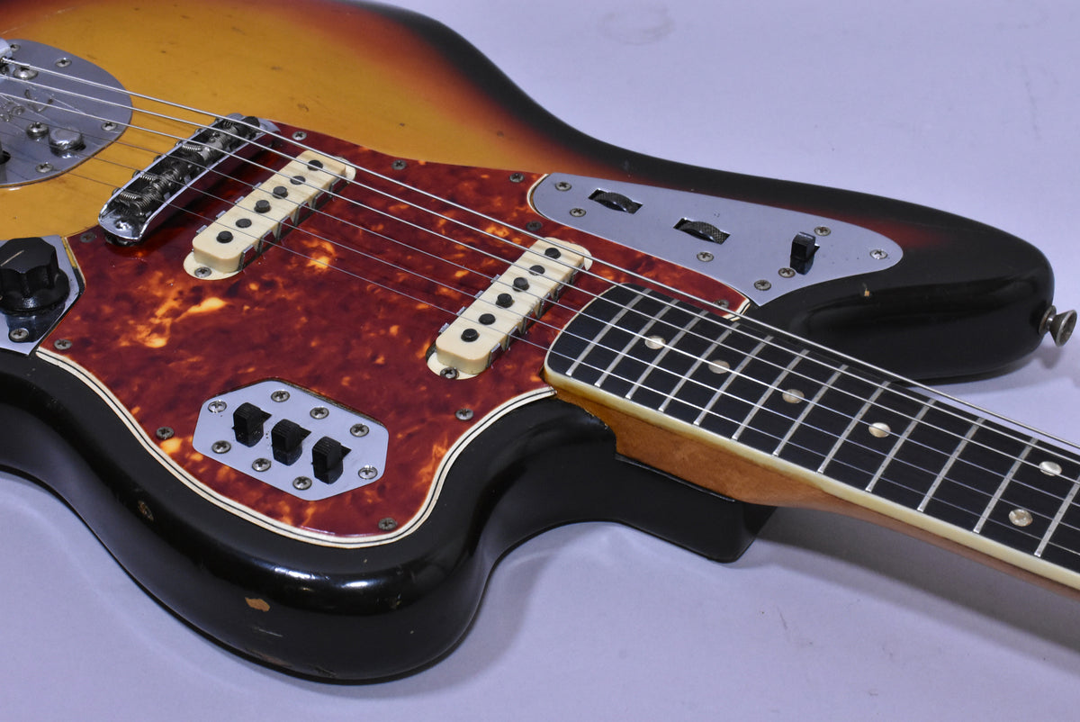 Upper body of a sunburst guitar with a tortoiseshell pickguard, showing two cream pickups and chrome control plates.