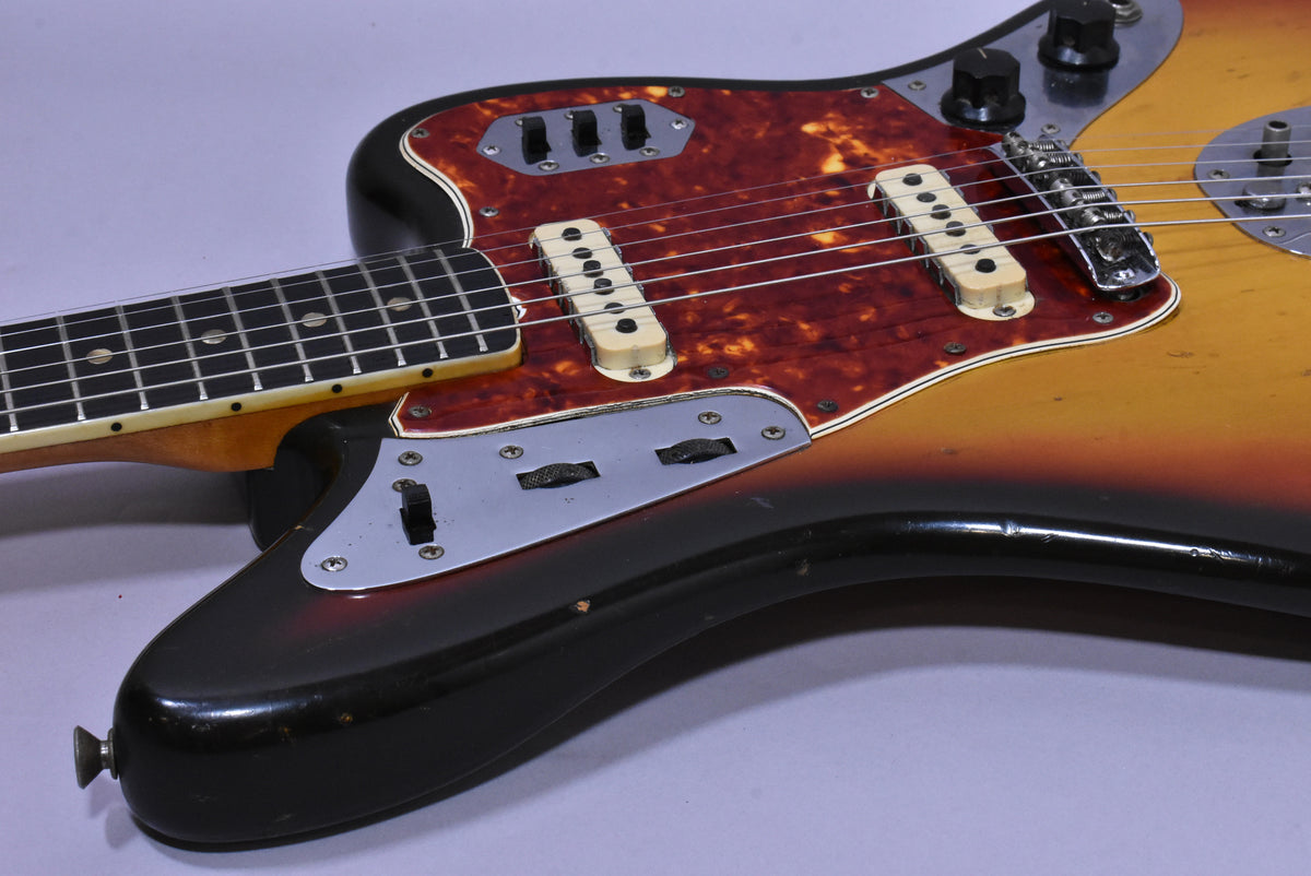 Close-up of the guitar body, showing the sunburst finish, tortoiseshell pickguard, two pickups, and control plates with switches.